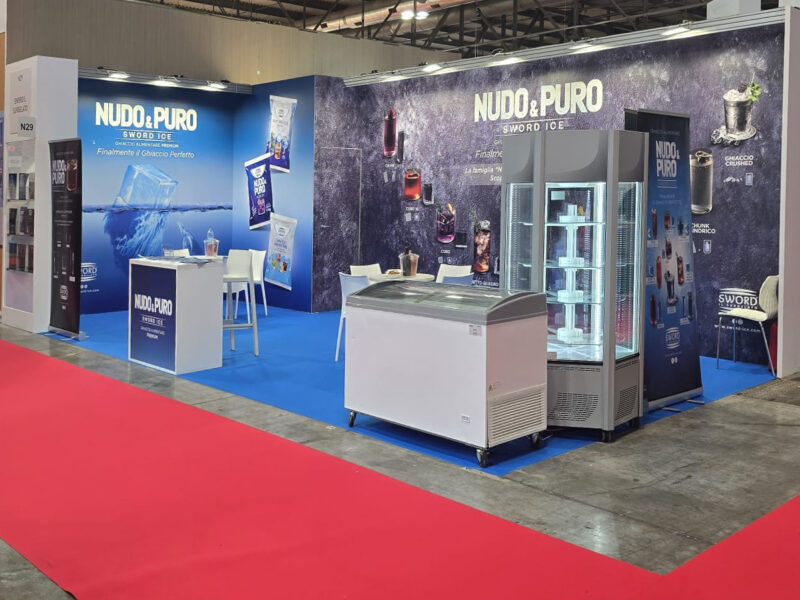 Stand Sword a TUTTOFOOD Milano 2025 con esposizione di Sword Ice e prodotti surgelati, tra cui bastoncini di merluzzo e gamberoni argentini. Incontro con visitatori e professionisti del settore Ho.Re.Ca. e GDO.