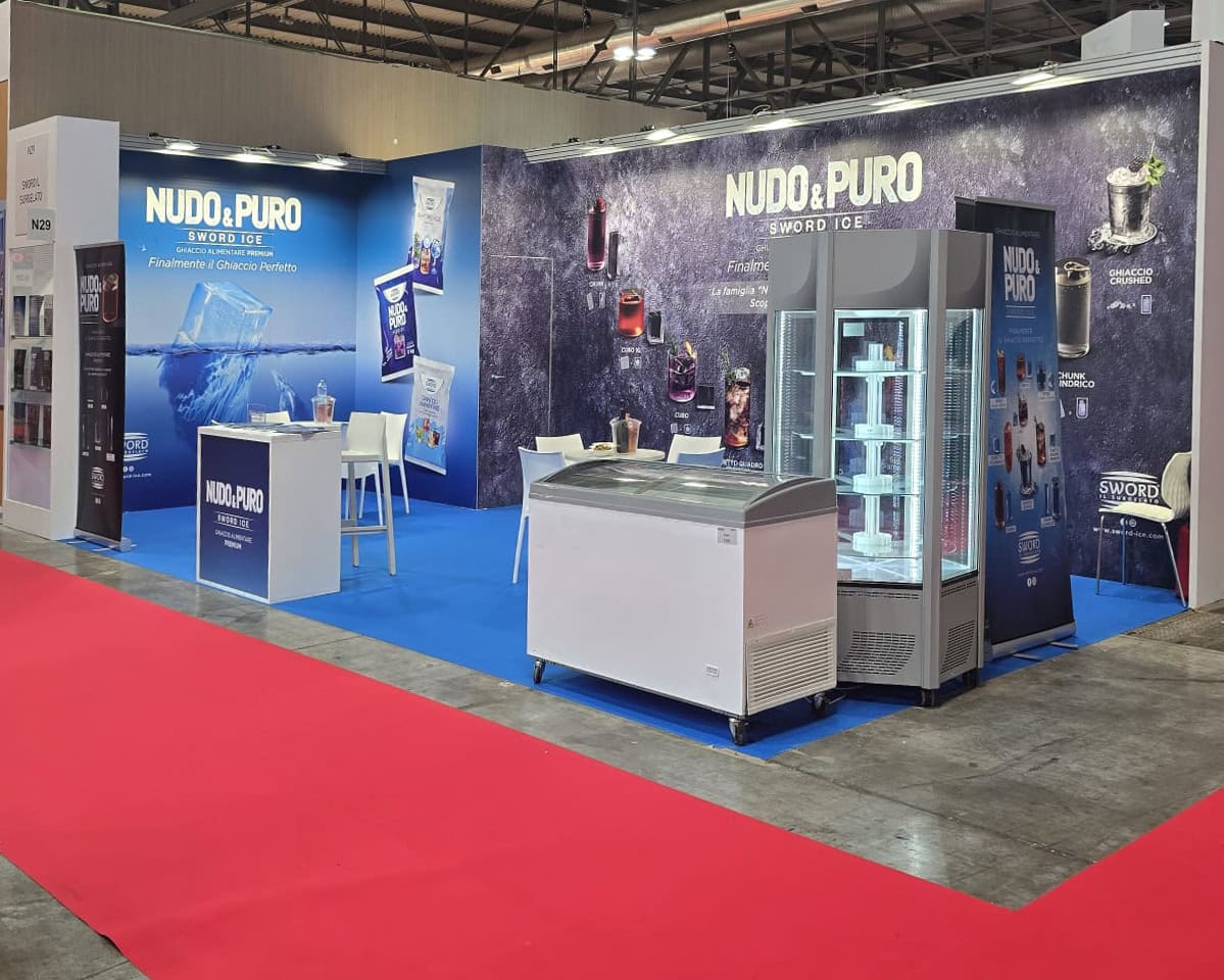 Stand Sword a TUTTOFOOD Milano 2025 con esposizione di Sword Ice e prodotti surgelati, tra cui bastoncini di merluzzo e gamberoni argentini. Incontro con visitatori e professionisti del settore Ho.Re.Ca. e GDO.